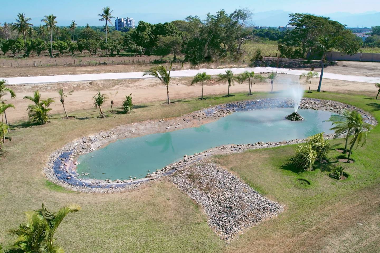 Lago con fuente y palmeras dentro de Del Lago Residencial, en Bucerías